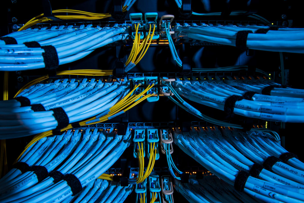 Fiber optic cables, center, and copper Ethernet cables feed into switches inside a communications room at an office in London, U.K., on Monday, May 21, 2018. The Department of Culture, Media and Sport will work with the Home Office to publish a white paper later this year setting out legislation, according to a statement, which will also seek to force tech giants to reveal how they target abusive and illegal online material posted by users. Photographer: Jason Alden/Bloomberg via Getty Images