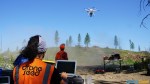 DroneSeed's drone operators fly a drone over an area being replanted.