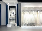photo of a fitting room with a three-way mirror and a rack of dresses