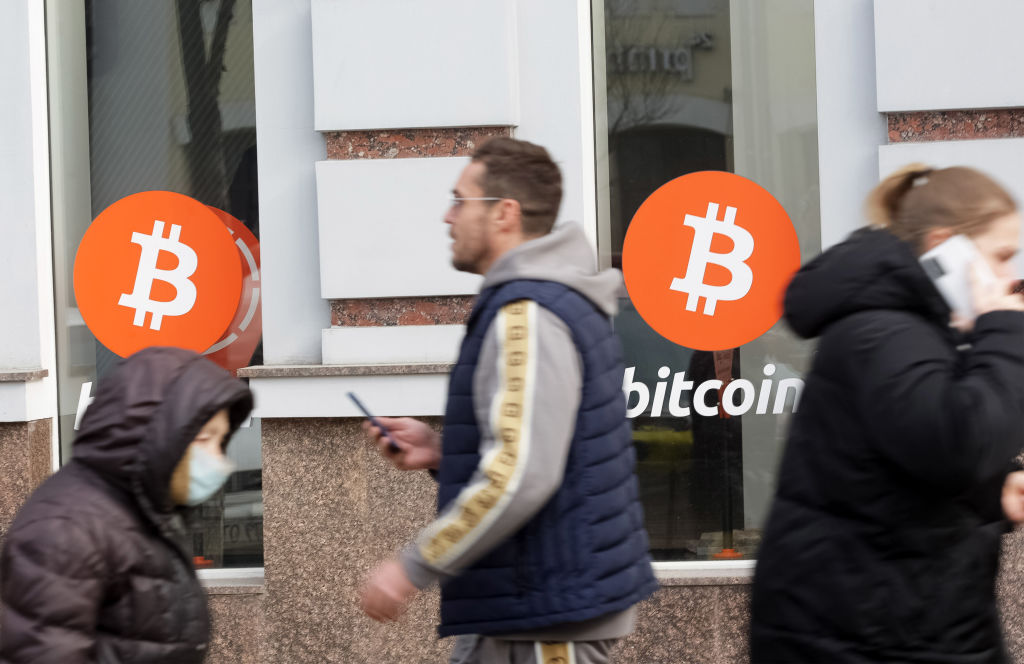 UKRAINE - 2021/03/09: People walk past an office of Bitcoin (BTC) cryptocurrency exchange. Over the past day, the price of Bitcoin cryptocurrency increased by 7.46% and reached $ 54,310, Bitcoin quotes have recovered their growth, and its capitalization has crossed the $ 1 trillion mark for the second time in history, as media reported. (Photo by Pavlo Gonchar/SOPA Images/LightRocket via Getty Images)