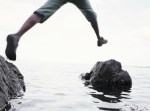 Young man jumping between rocks