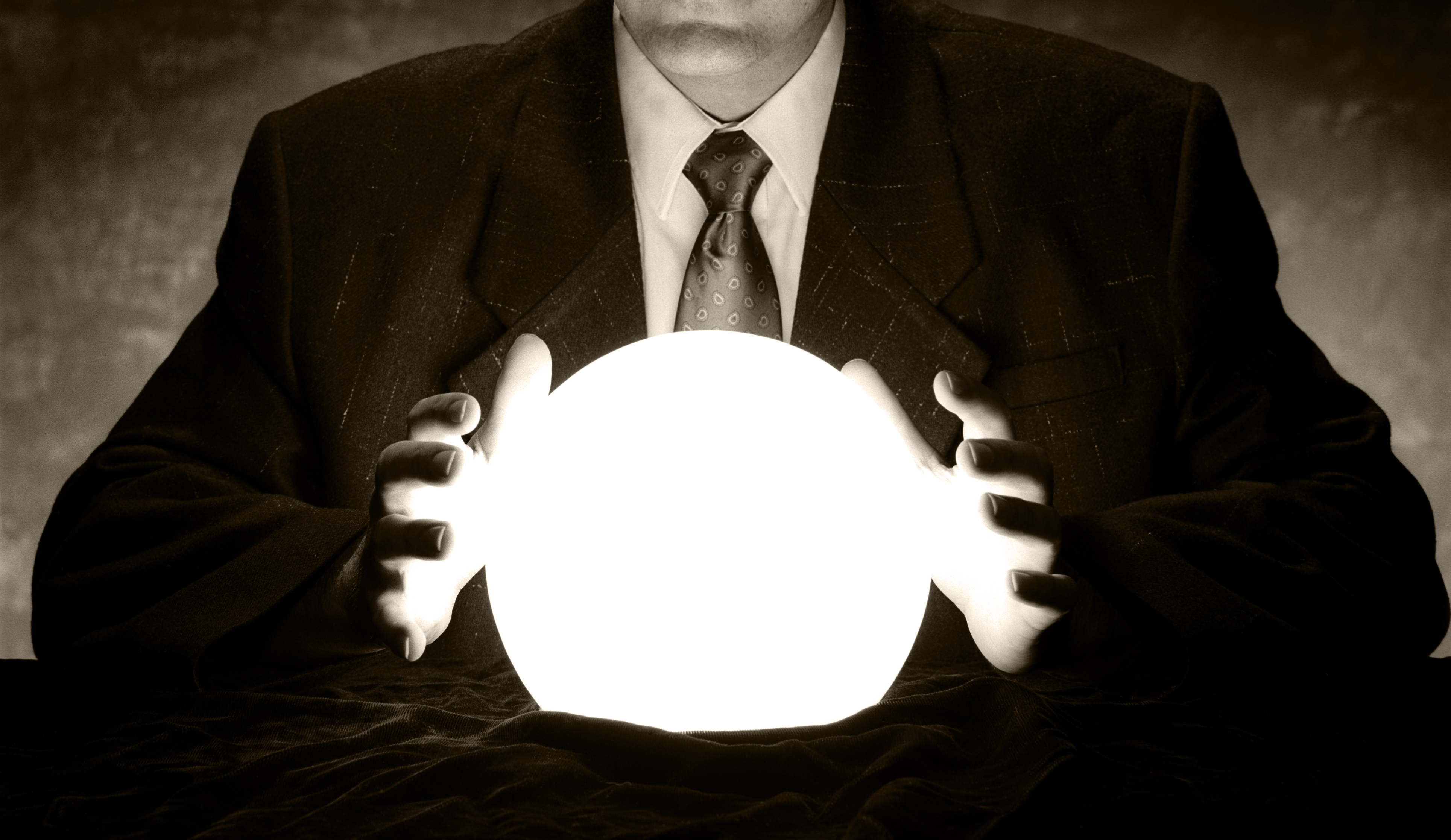 A businessman is consulting a crystal ball to foretell the future.