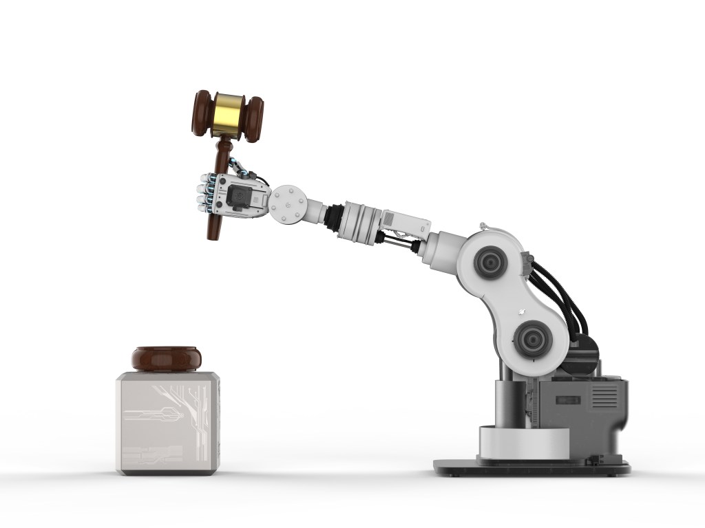 Image of a robotic hand holding a gavel to represent artificial intelligence innovation and regulation