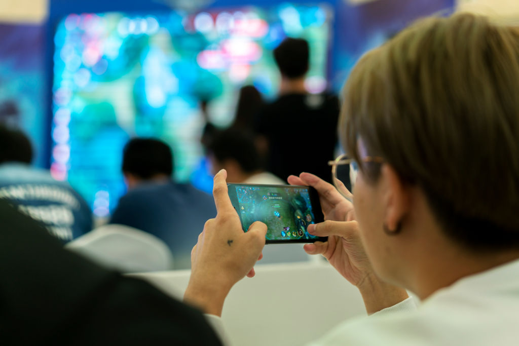 تیانجین ، چین - 2017/10/01: بازیکنان جوان در یک مسابقه نبرد بازی موبایل Arena of Valor که در یک مرکز خرید برگزار می شود رقابت می کنند.  Arena of Valor: 5v5 Arena Game ، محبوب ترین بازی موبایل چین است که توسط Tencent Inc توسعه یافته است ، که بزرگترین توسعه دهنده بازی های تلفن همراه در جهان است.  در نیمه اول سال 2017 ، فروش بازار بازی های آنلاین چین به 99.78 میلیارد یوان رسید که از این میزان درآمد صنعت بازی های موبایل به 56.2 میلیارد یوان رسید و در رتبه اول جهان قرار گرفت.