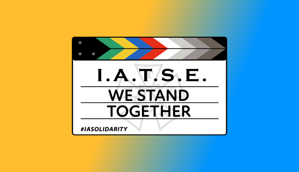 A movie set clapper with "IATSE - We stand together" written on it