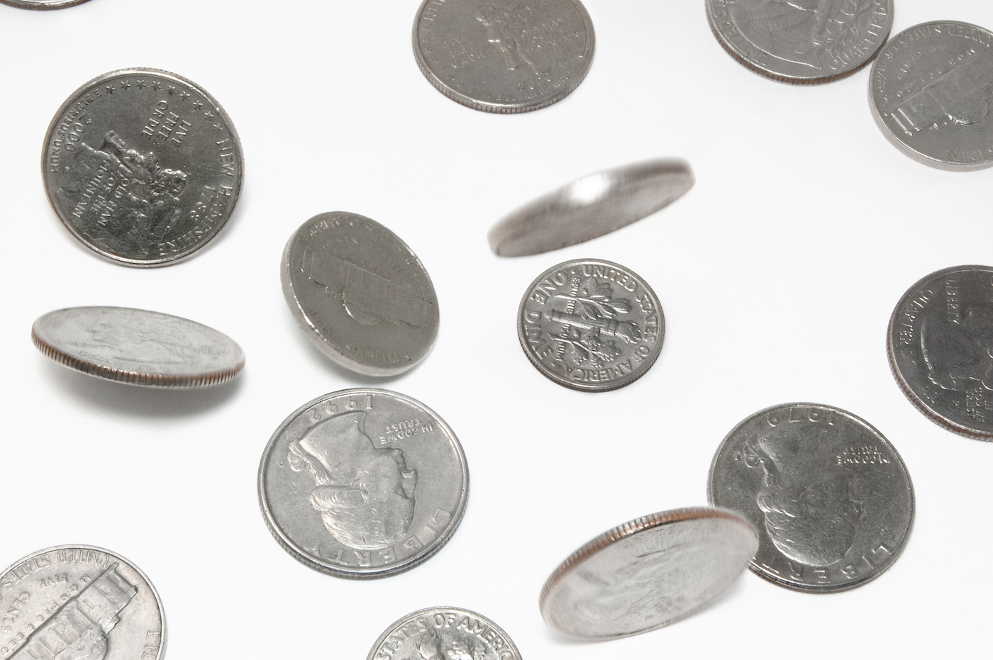 Change falling on white background. Dimes and quarters. All in focus with slight motion blur