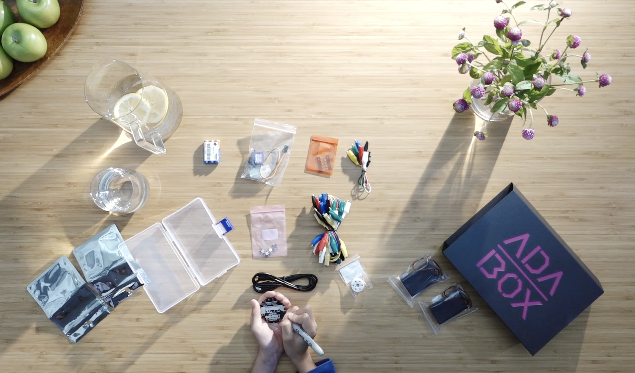 AdaFruit's subscription maker box, AdaBox, shown on a table with a variety of components