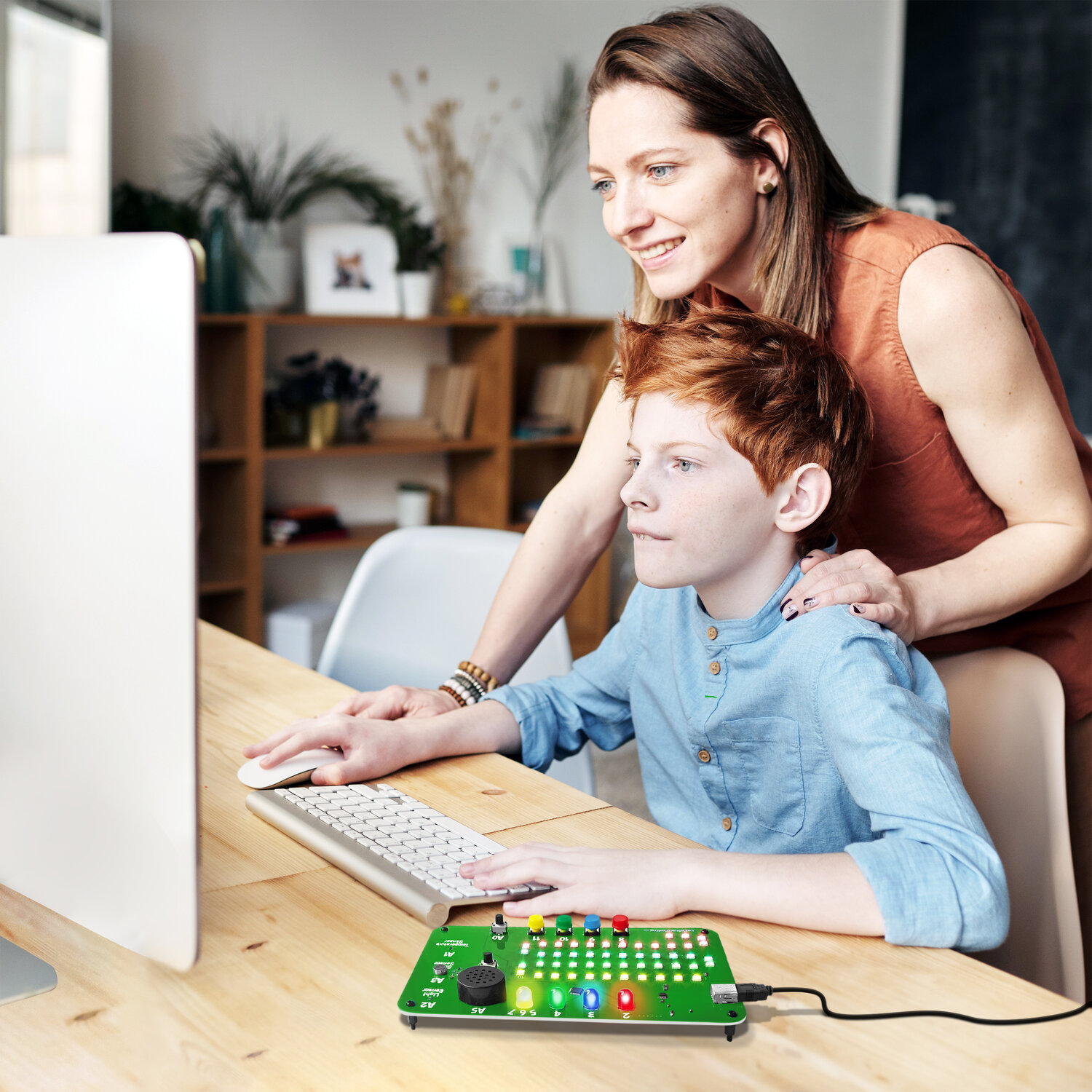 Code Lab aprende a codificar la placa electrónica que muestra un niño en uso mediante una computadora que observa su madre