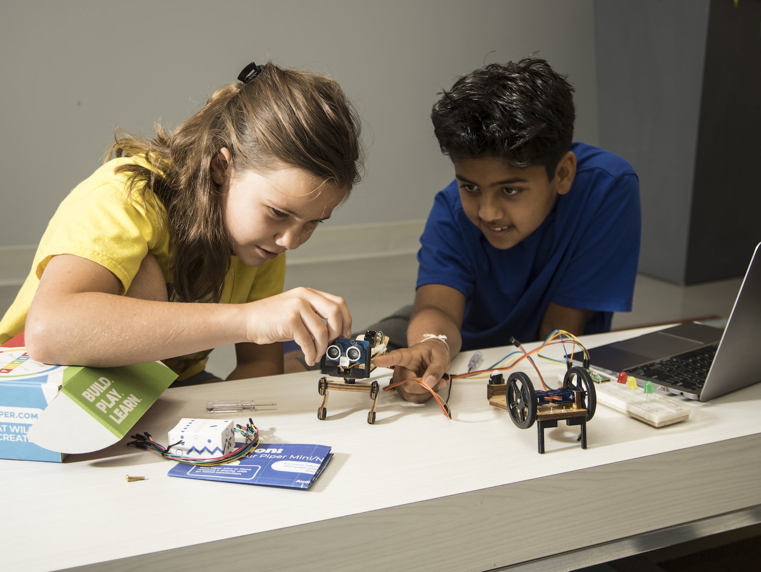 Se muestra el kit Piper's Robotics Expedition con niños trabajando en cómo programar los bots