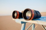 Close-up of binoculars on table by the sea during sunset, the sunset is reflected in the glass of the binoculars (Close-up of binoculars on table by the sea during sunset, the sunset is reflected in the glass of the binoculars, ASCII, 113 components,
