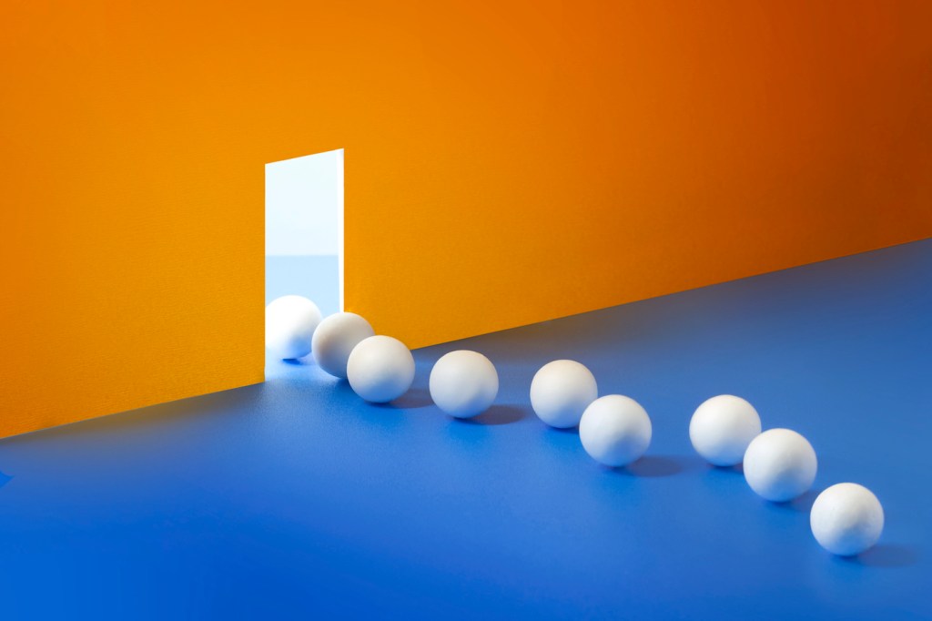 A row of spheres leaving through an opening to another brighter side.