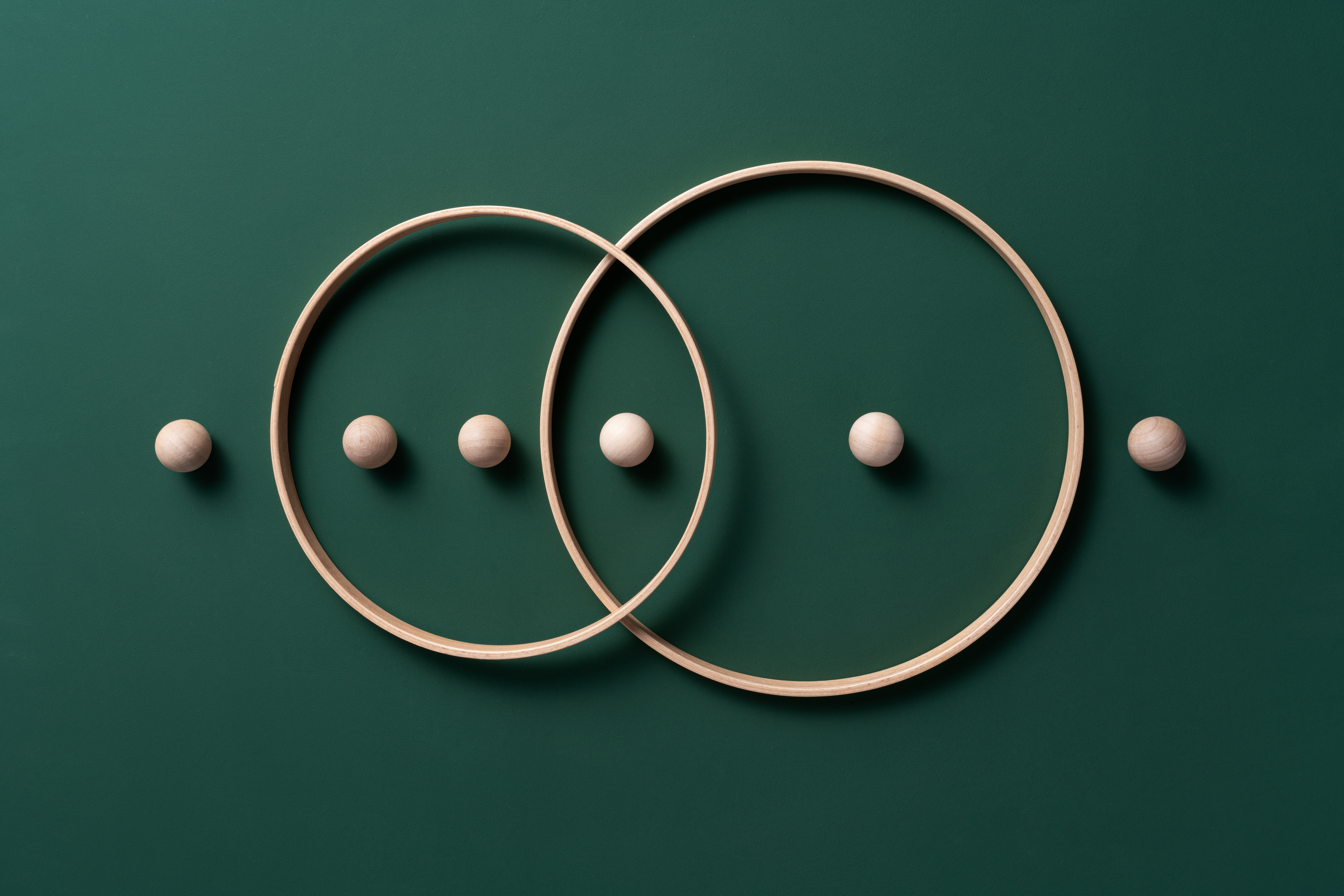 Image of crossing rings with spheres on a green background.