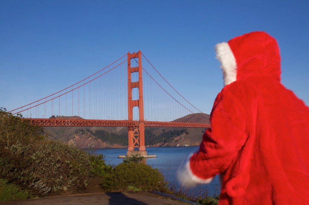 Santa Claus in the foreground Golden Gate Bridge in the distance.