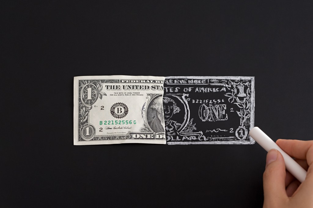 Image of a dollar bill mirrored against a drawn dollar in chalk to represent forgery.