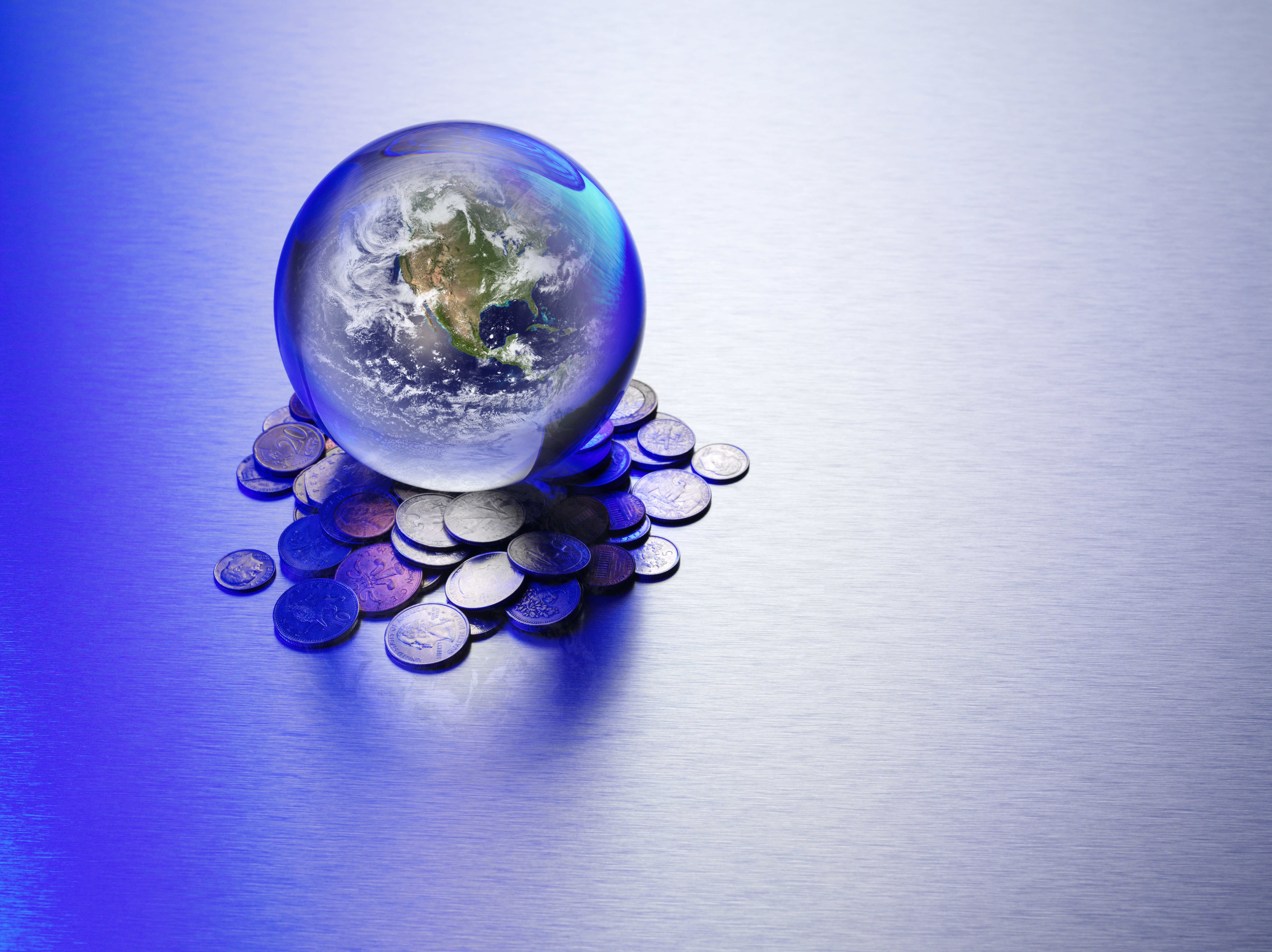 Image of a world map inside a crystal ball atop a pile of coins to represent predictions in venture capital for the year ahead.