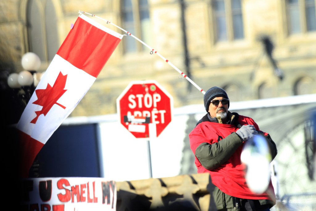 A protestor with a Canadian flag on the streets of Ottawa