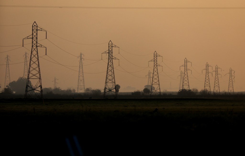 A photo of power lines in the distance at sunset.