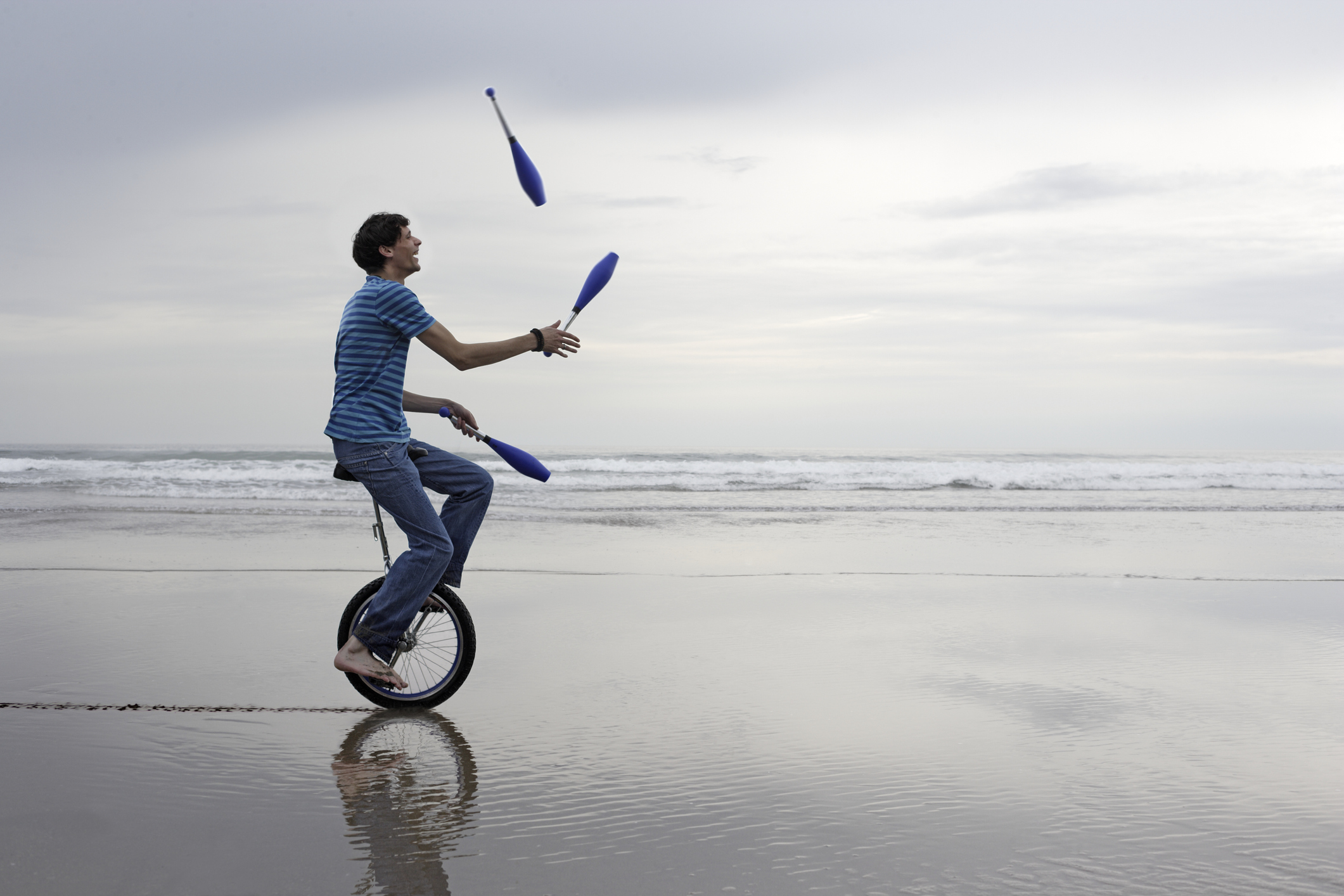 Man riding unicycle while juggling