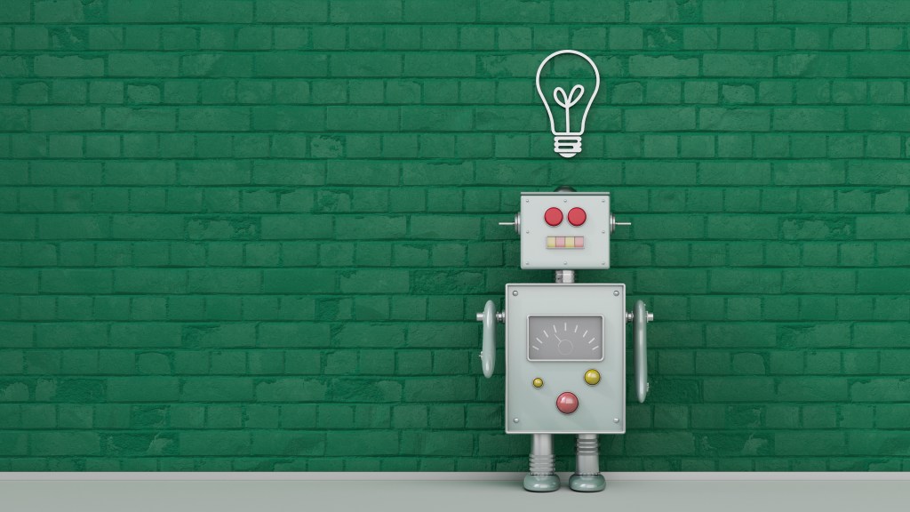 Image of a robot under light bulb painted on a green brick wall.