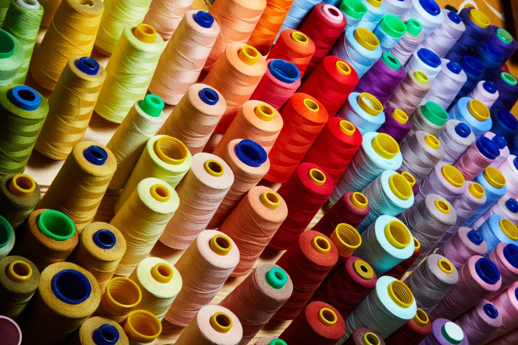 Many colorful spools of thread. Various rolls of vivid sewing bobbins
