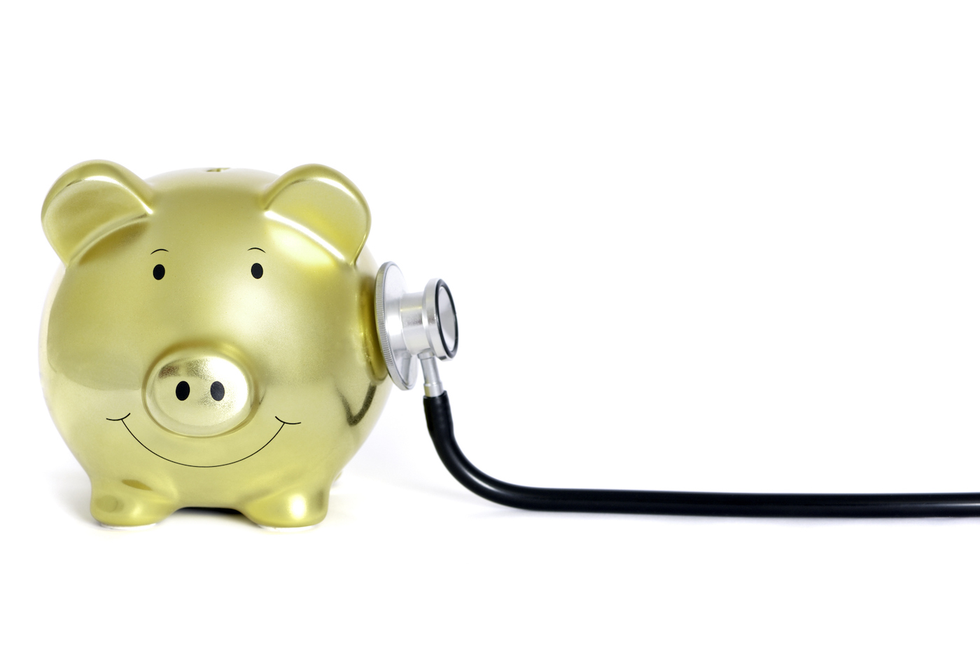 Conceptual image of a golden piggy bank and a stethoscope isolated on pure white, selective focus on the piggy bank