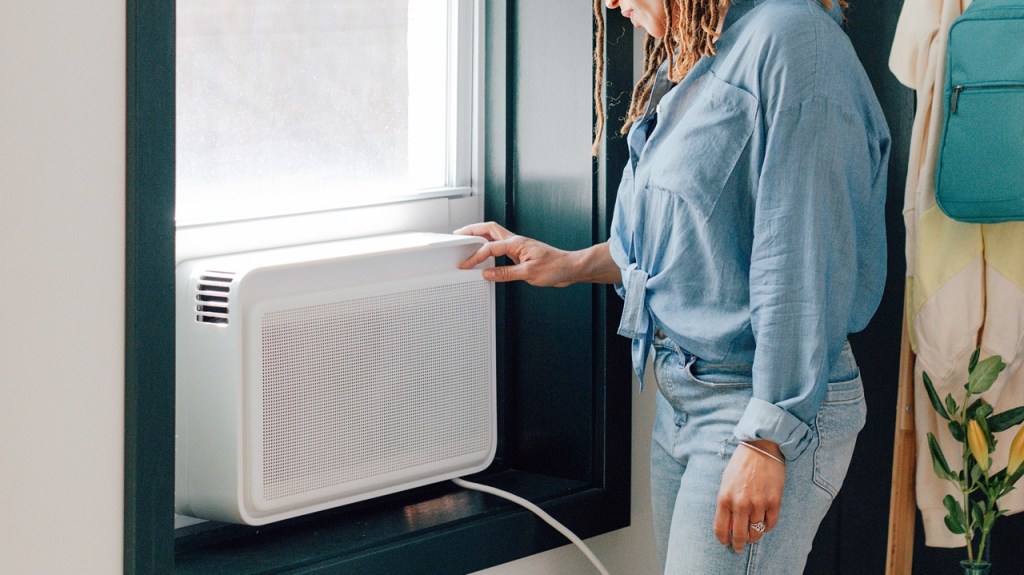 A woman is adjusting a wind air conditioning unit