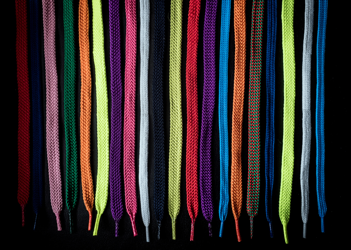 Close-up of multi-colored shoelaces on a black background
