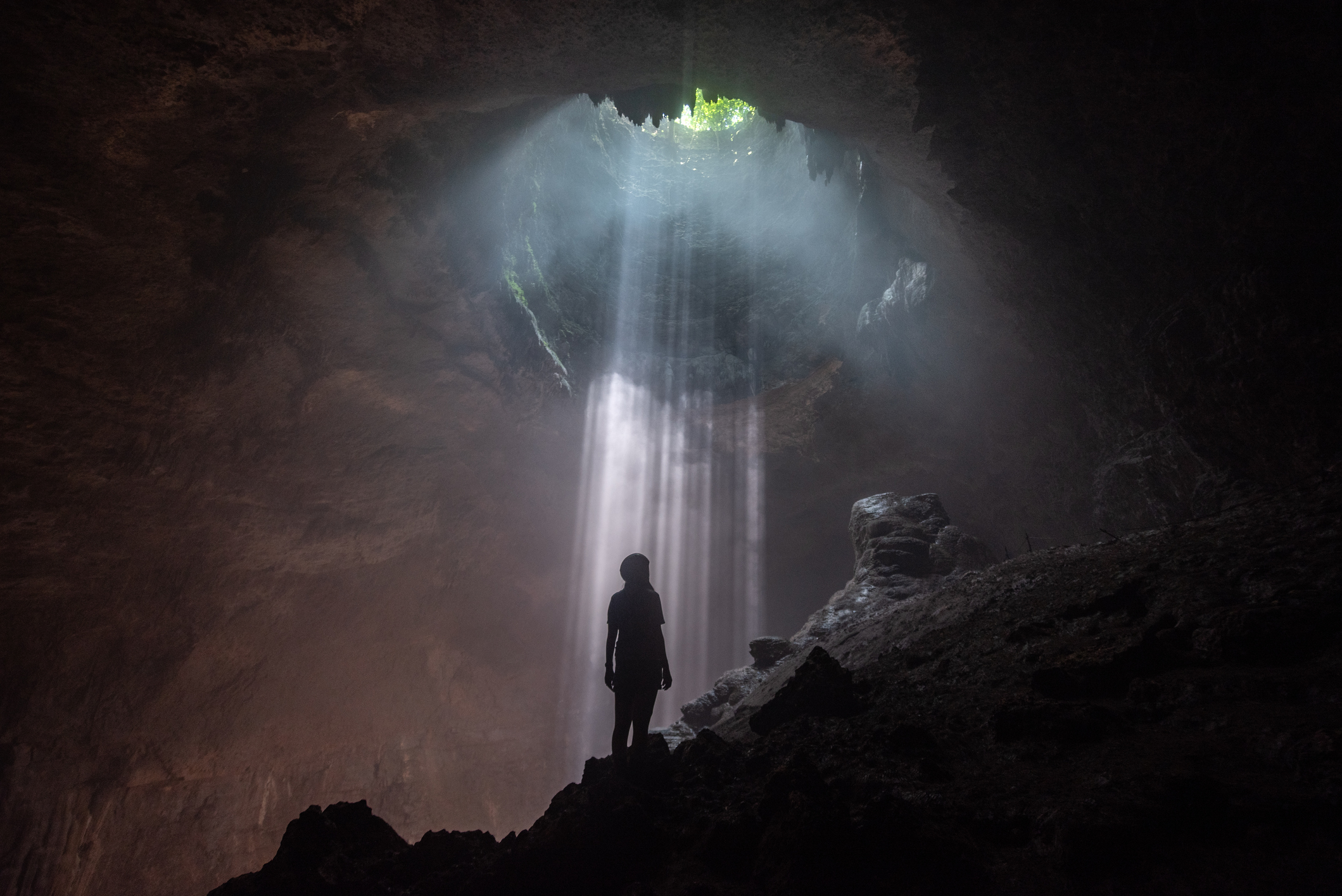 女人抬头看着 Jomblang 洞穴的开幕式
