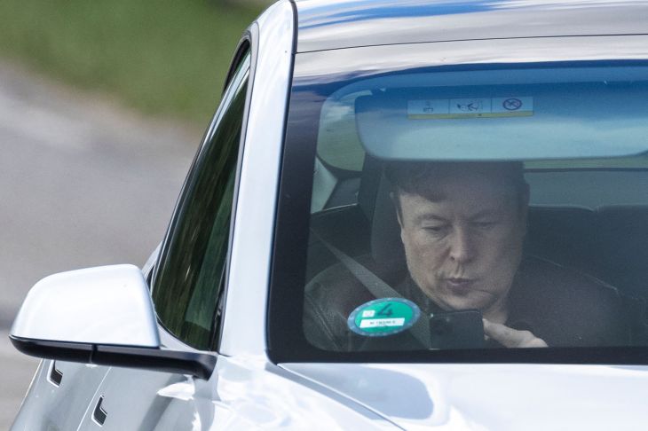 特斯拉首席执行官埃隆·马斯克（Elon Musk）坐在汽车中使用他的移动设备前往位于德国东北部柏林附近格伦海德的美国电动汽车制造商特斯拉的新工厂（即所谓的“超级工厂”）的施工现场