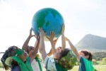 Group of children holding up a large globe