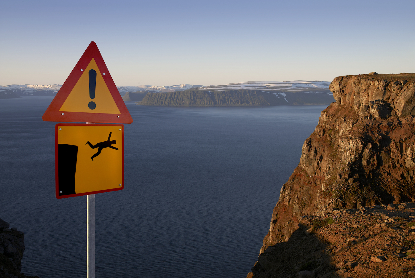 Warning sign cliff ahead, West fjords, Iceland