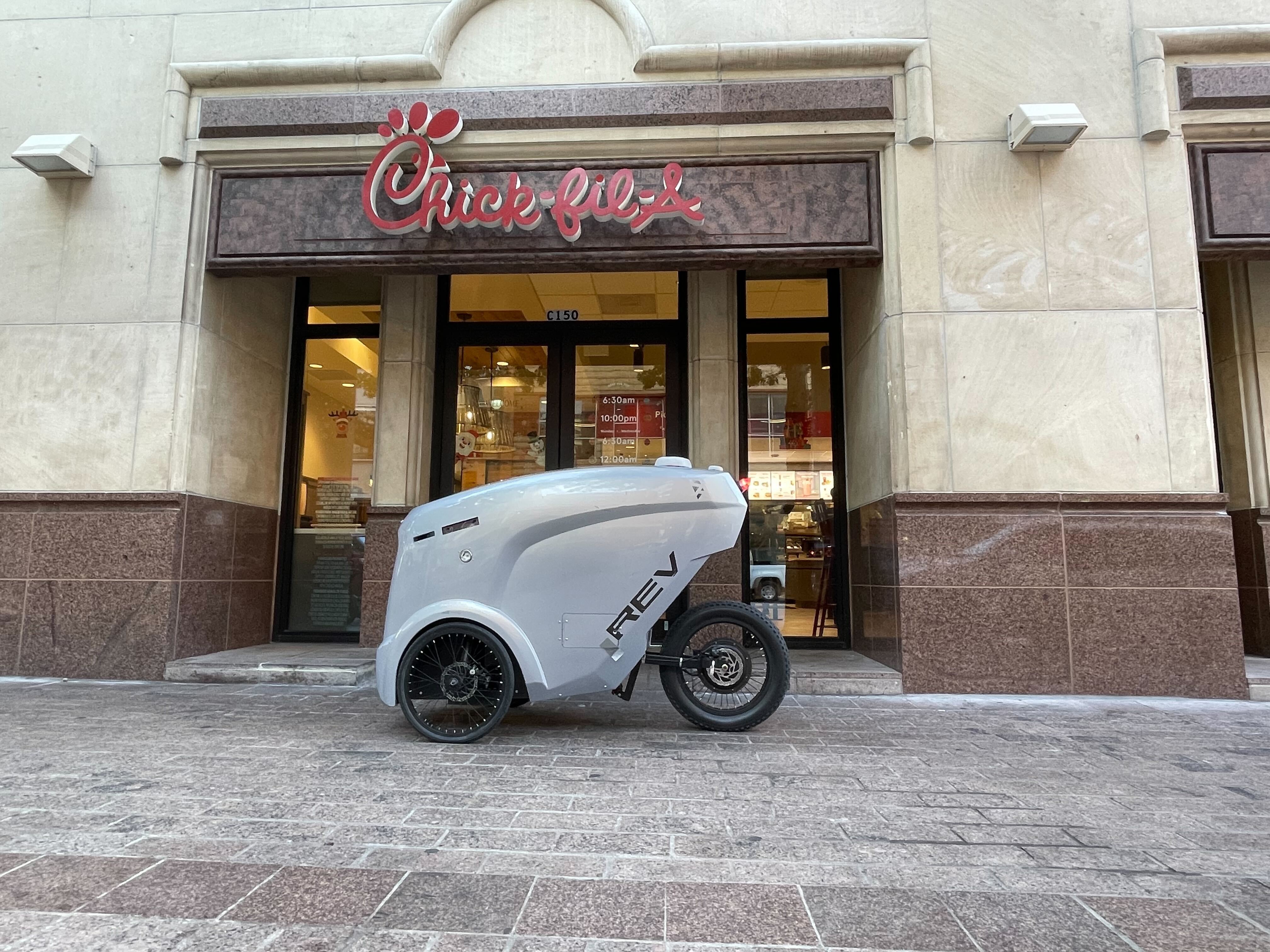 Refraction AI delivery robot in front of Chick-fil-A in Austin