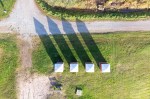 Four old beach huts photographed from straight above. The shadows seem to form four arrows pointing to the same directions.
