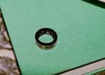Black Gucci x Oura ring on green book