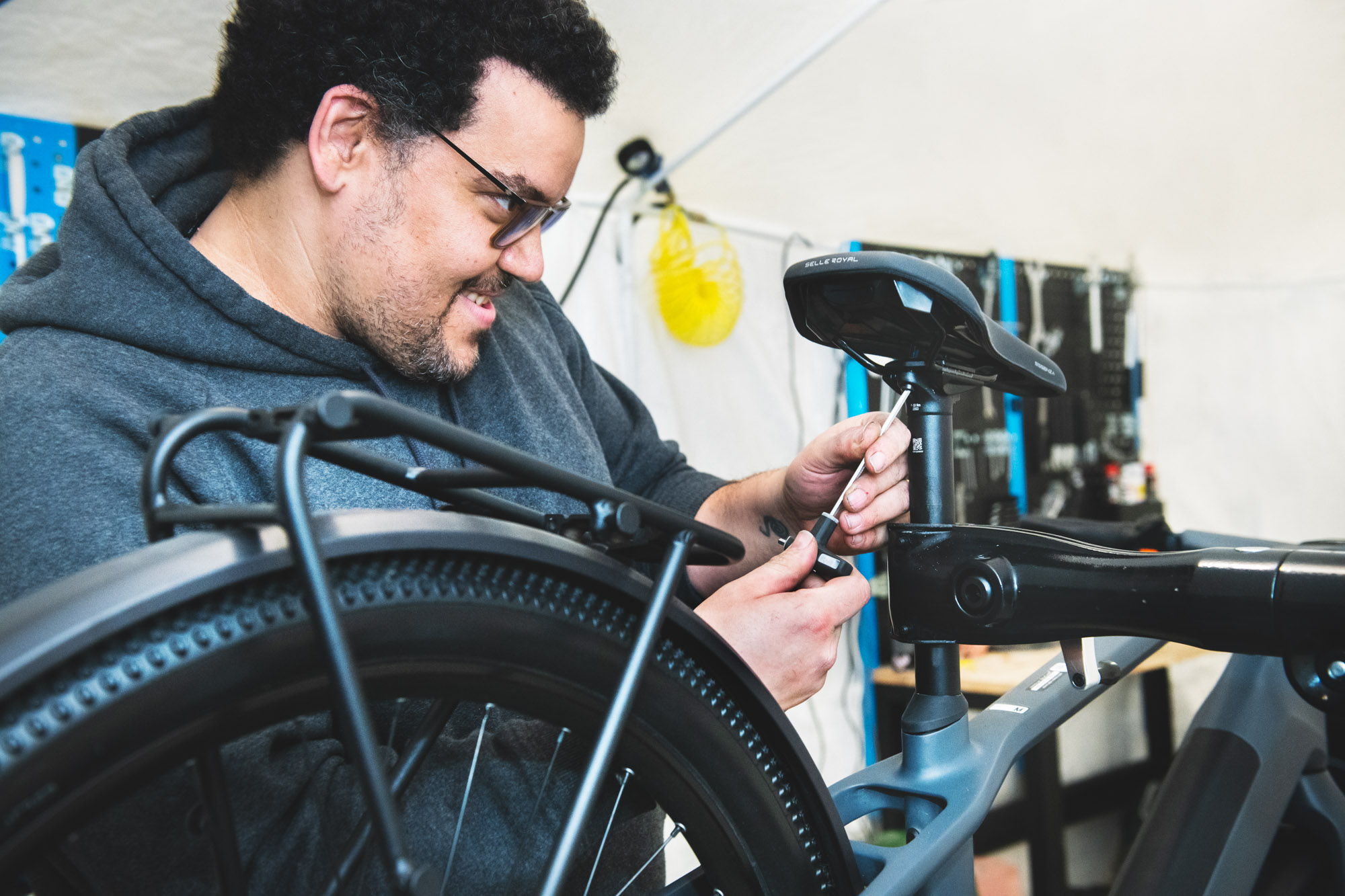 Un reparador de bicicletas revisando el asiento de una bicicleta