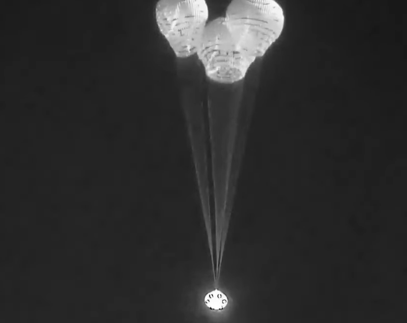 Animación de Starliner flotando bajo tres paracaídas.