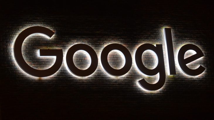 Signo del logotipo de Google con retroiluminación blanca sobre fondo oscuro