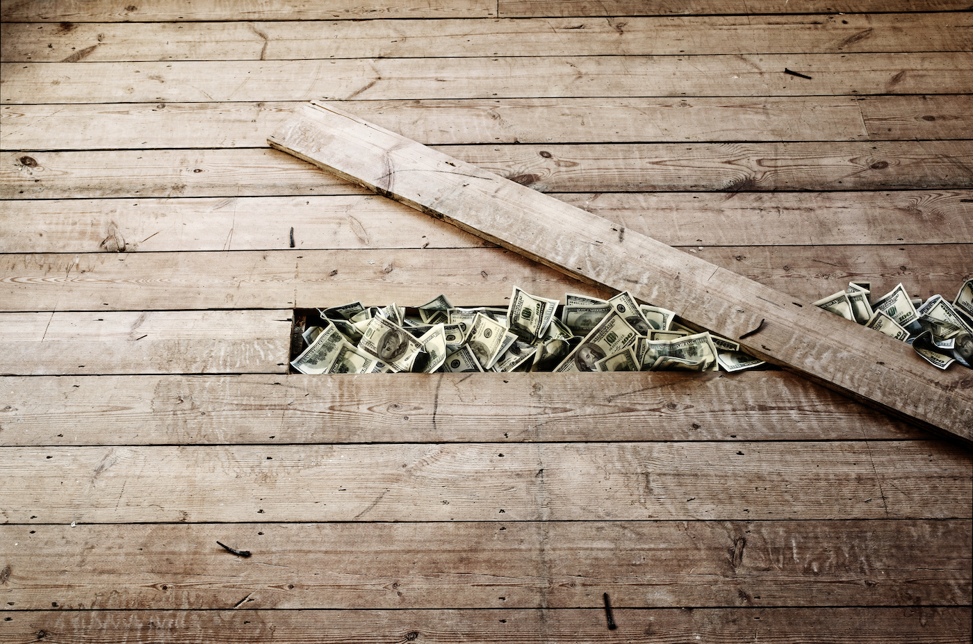 $100 bills hidden under a floorboard