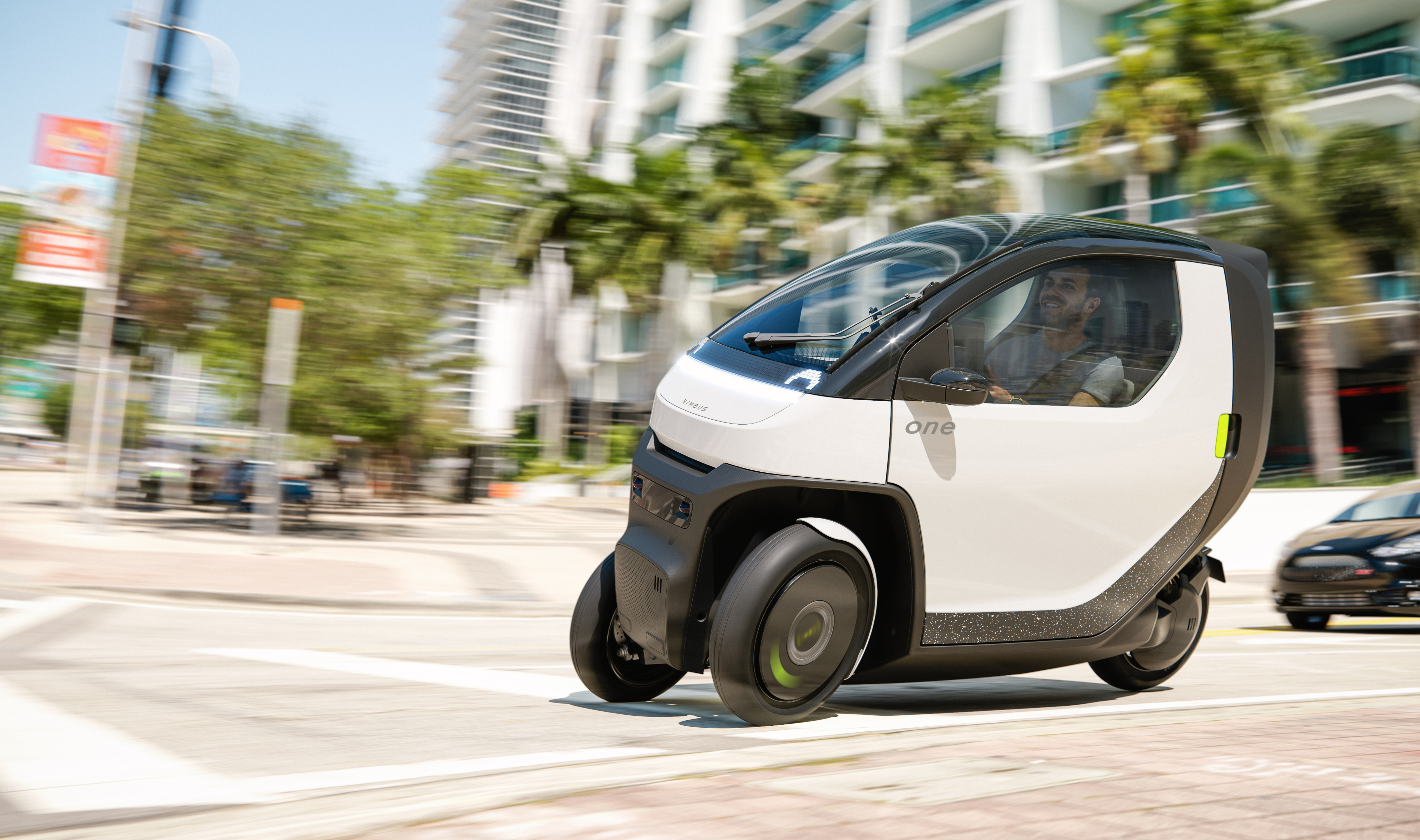 Nimbus One tilting 3-wheel small EV driving in the city