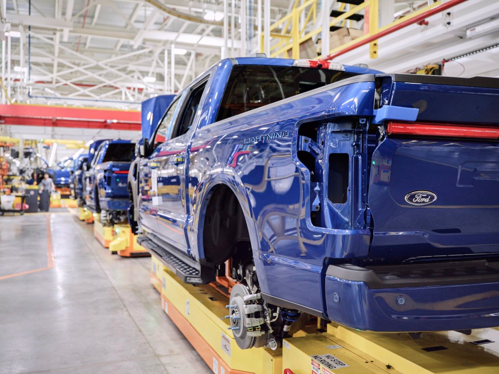 Centro de vehículos eléctricos Ford Rogue;  Camiones azules alineados en la línea de montaje