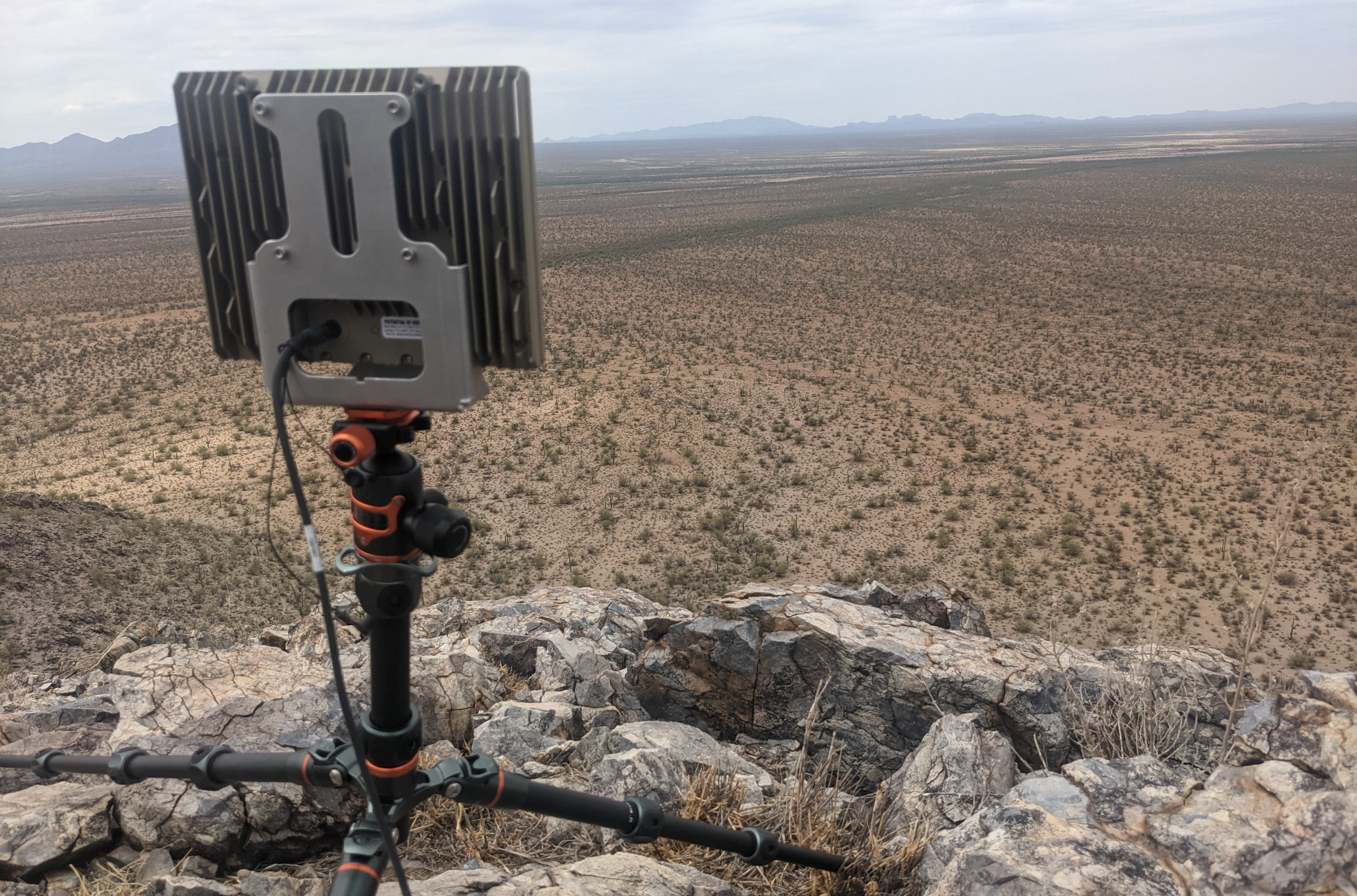 An Echodyne radar on a small tripod overseeing a desert area.