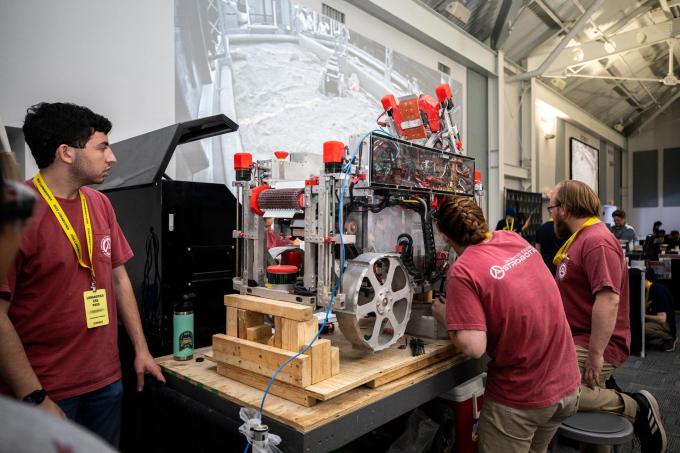 öğrenciler ay madenciliği robotunu inceliyor