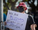 A person holding a sign at a protest that says "We are Blizzard. Every voice matters."