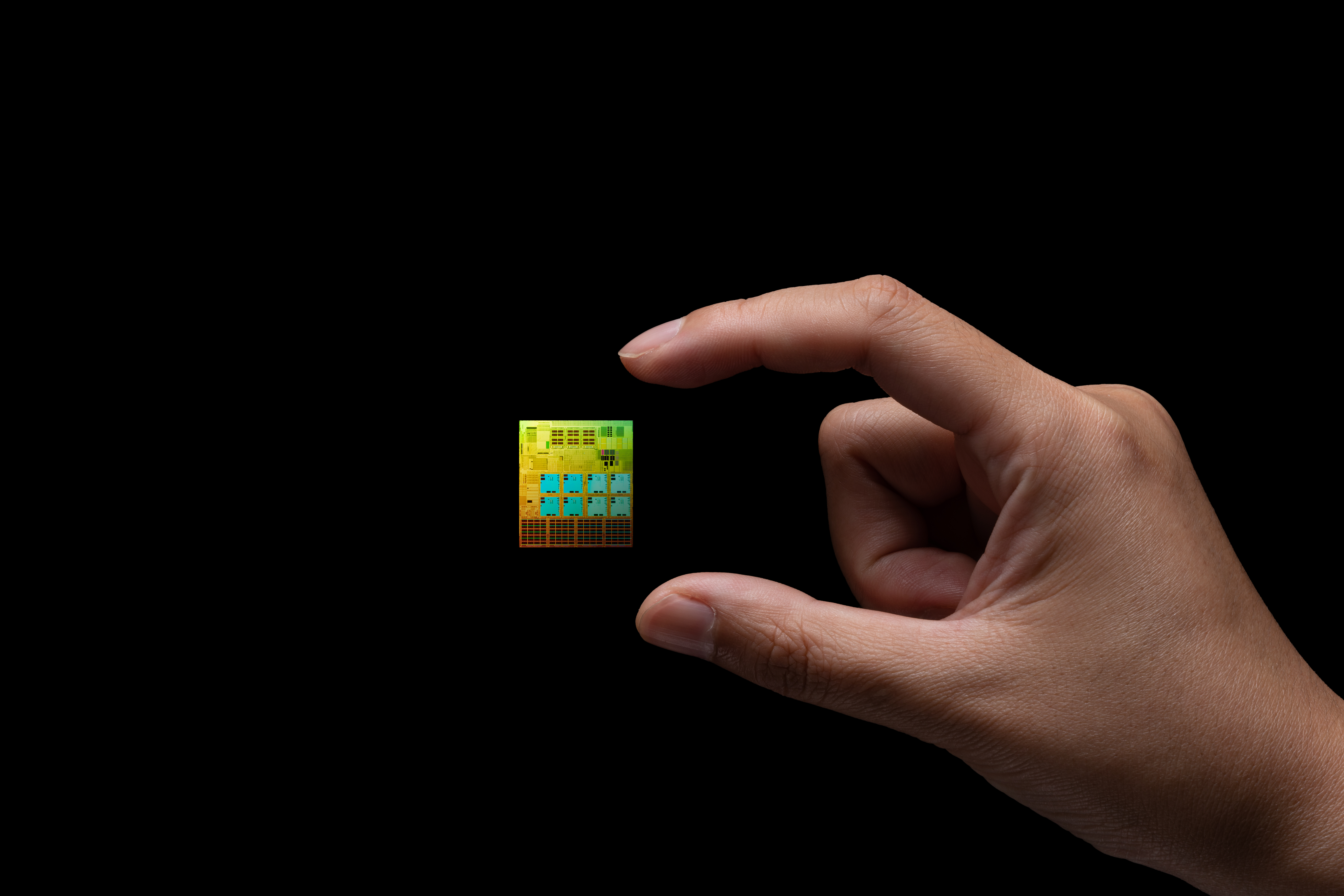 Image of a semiconductor levitating between two fingers on a black background.