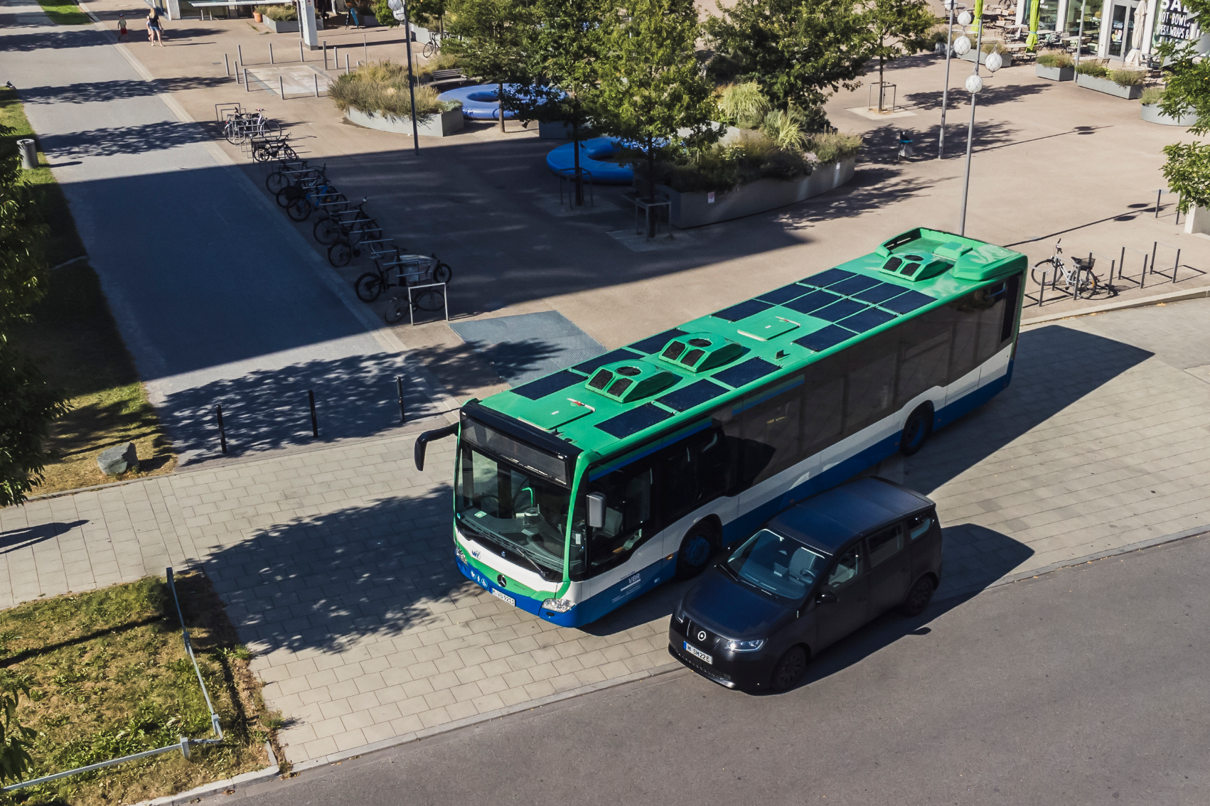 Вид с высоты птичьего полета на комплект солнечных батарей Sono Motors для автобусов — солнечные панели на верхней части зеленого автобуса