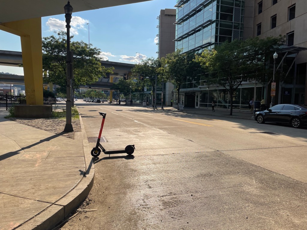 Image of a Spin scooter abandoned in the middle of a street on Pittsburgh's North Shore.