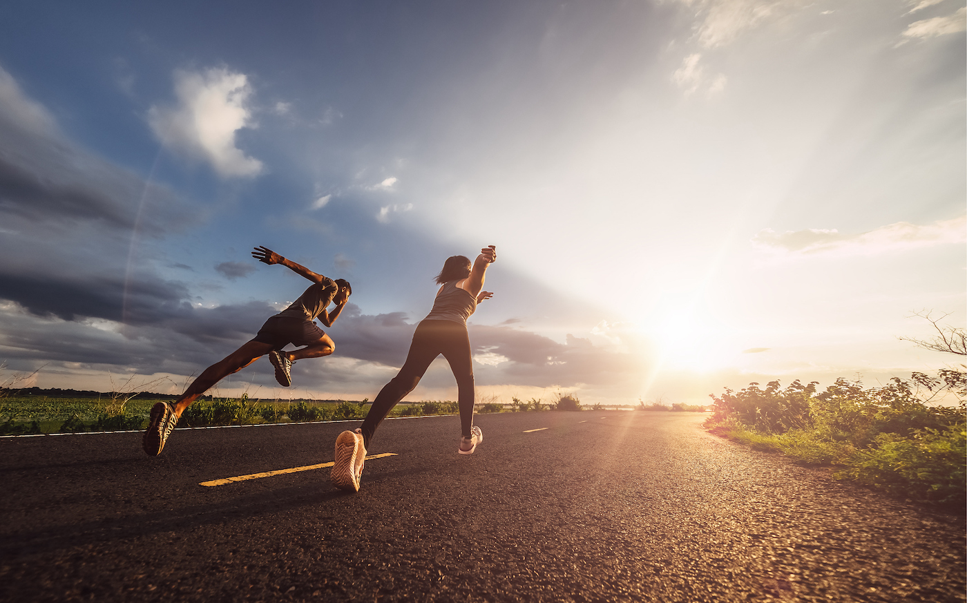 A young couple runs a race at sunset.  Fitness runner fitness runner during outdoor workout.