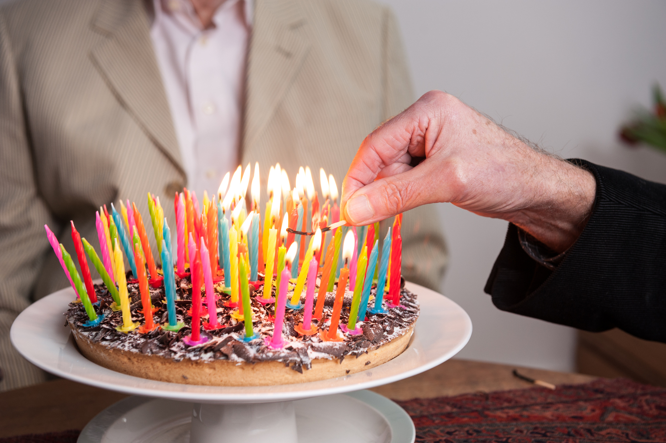 Man lighting 93 candles on a cake;  Longevity Technology Investor Survey