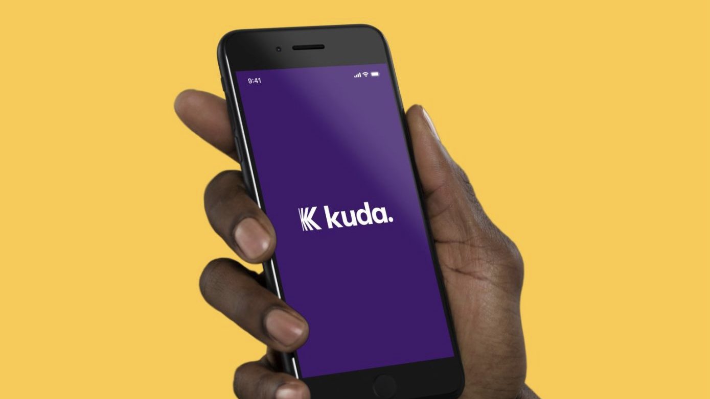 Hand holding smartphone displaying Kuda logo