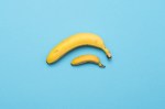 baby banana compare size with banana on blue background. size penis concept